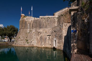 Kampana Kulesi ve taş kent duvarları hendek suyuna yansıyor - Kotor, Karadağ