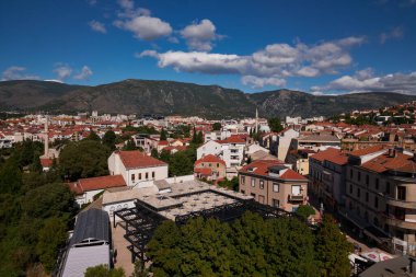 Modern mimari ve dağ zeminine sahip kentsel ufuk çizgisi - Mostar, Bosna-Hersek
