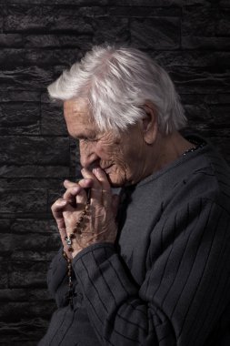 Old grandmother praying. clipart