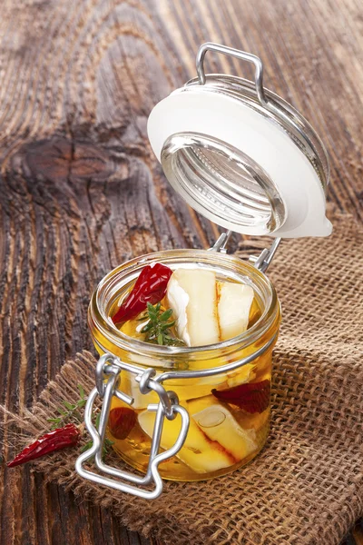 Marinated cheese in glass jar. — Stock Photo, Image