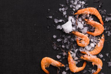Siyah arka plan üzerine buz üstünde karides.