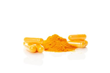 Turmeric (curcumin) powder heap and capsules isolated on white background. Anti-inflammatory nutritional supplement clipart