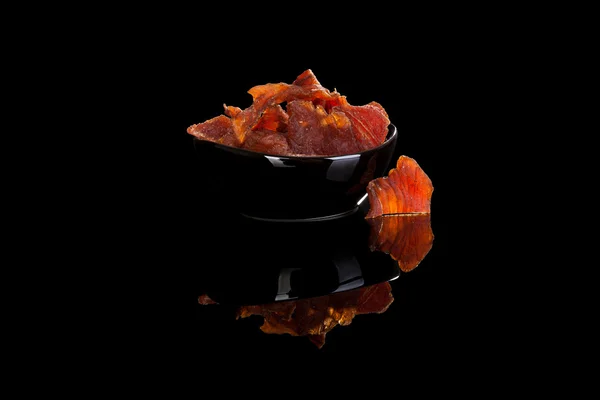 Beef jerky, dried meat in bowl isolated on black — Stock Photo, Image