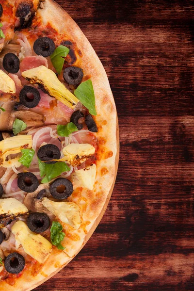 Bunte Pizza auf dunklem Holzgrund. — Stockfoto