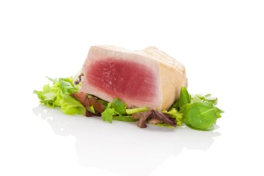 Lezzetli orkinos biftek üzerinde yeşil salata.