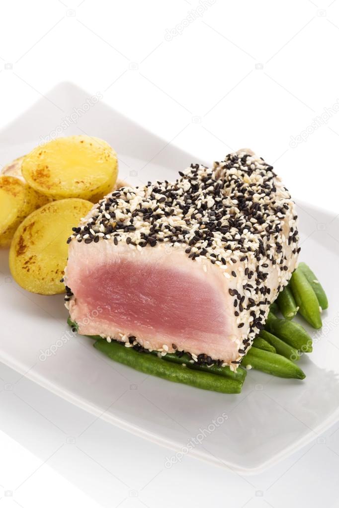 Tuna steak with beans and potatoes.