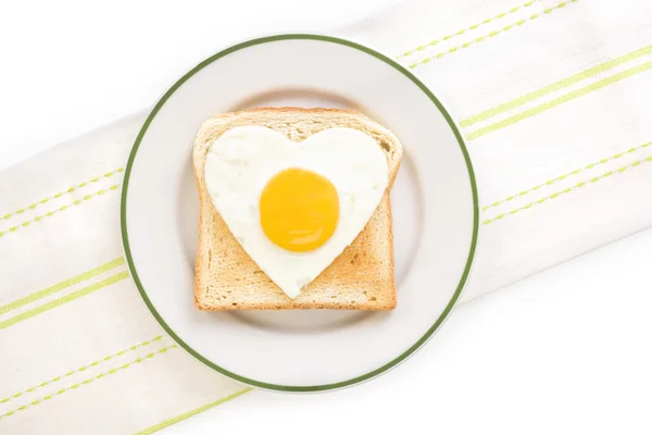 Uovo fritto lato sole a forma di cuore sul piatto — Foto Stock