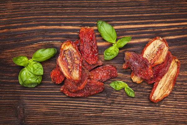 Tomates secos y hojas de albahaca fresca —  Fotos de Stock