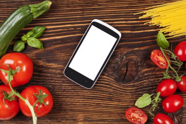 Fresh vegetables and pasta on wooden table