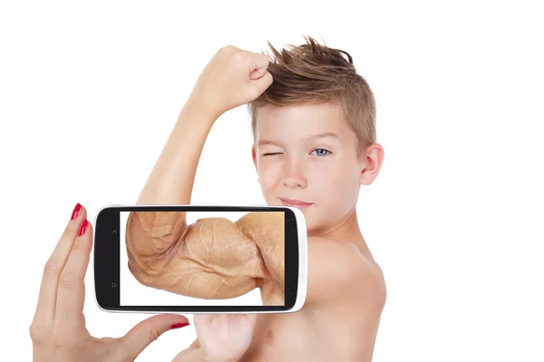 Charming boy showing muscle with future vision on smartphone screen — Stock Photo, Image