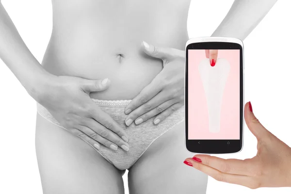 Beautiful woman touching her belly and mobile phone with ovulation cycle app Zdjęcia Stockowe bez tantiem