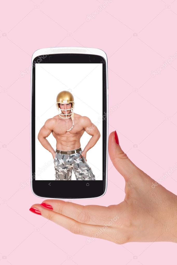 Female hands holding smartphone with picture of handsome man