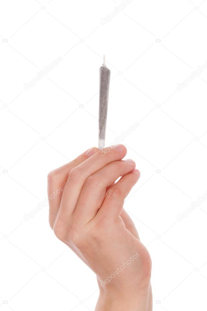 Holding cannabis joint.