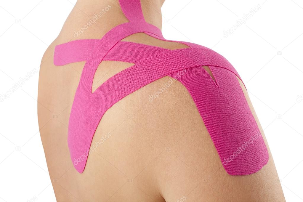 applying kinesiology tape to shoulder