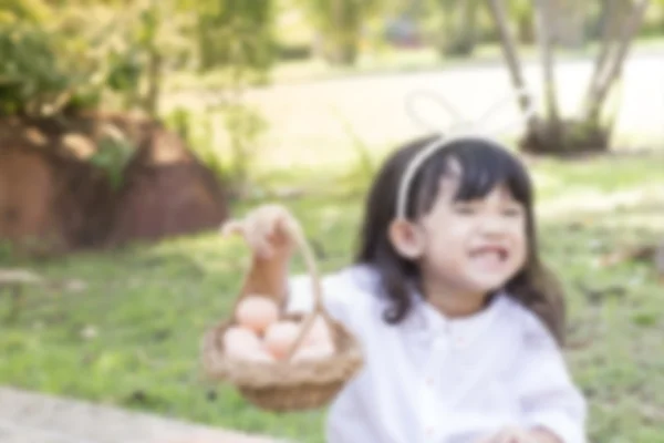 Adorável menina vestindo orelhas de coelho segurando uma cesta — Fotografia de Stock