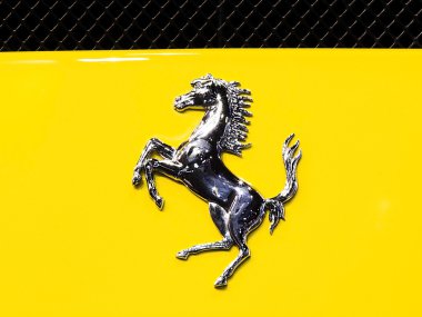 logo of Ferrari on yellow super sport car