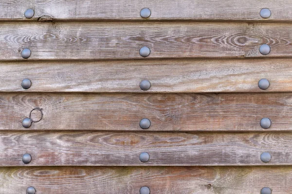 Wood paneling of an old ship with metal rivets, texture, background