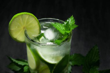 Kireç, nane ve buzlu taze ev yapımı mojito kokteyli siyah arka planda, yakın plan, kopyalama alanı