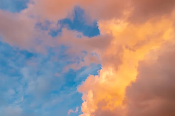 Bellissimo paesaggio nuvoloso - nuvole rosa-arancio ai raggi del sole contro il cielo blu — Foto Stock