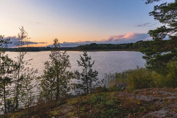 Puesta de sol en un lago con costas rocosas en Karelia —  Fotos de Stock
