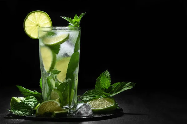 Świeże domowe koktajle mojito w wysokiej szklance z limonką, miętą i lodem na czarnym tle, przestrzeń do kopiowania — Zdjęcie stockowe