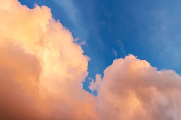 Vackra molnlandskap - rosa-orange moln i solens strålar mot den blå himlen — Stockfoto