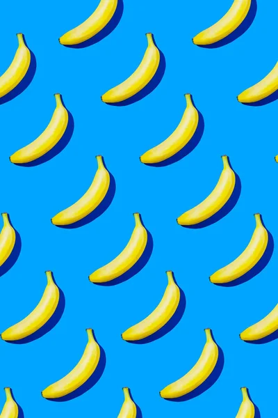 Banana pattern in hard light on blue background