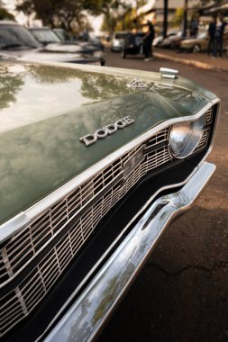 Klasik bir Dodge 'un ön tarafında, krom metal ızgarayı, ön amblemi ve kaputun açısal hatlarını vurguluyor.