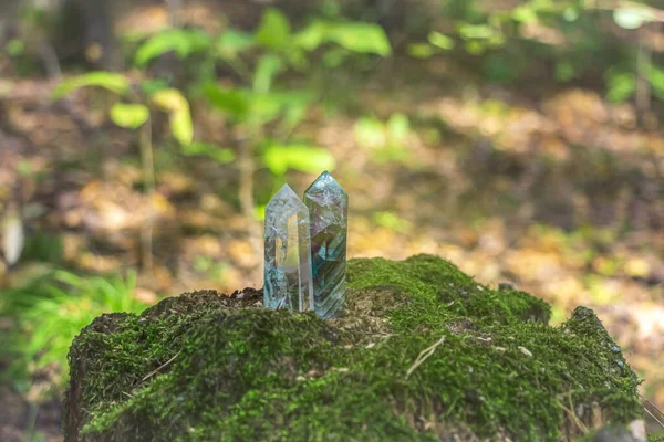 Gemstones fluorite, quartz crystal. Magic rock for mystic ritual, witchcraft Wiccan and spiritual practice on stump in forest. Meditation reiki, spiritual healing consept. Out focus, bakclight