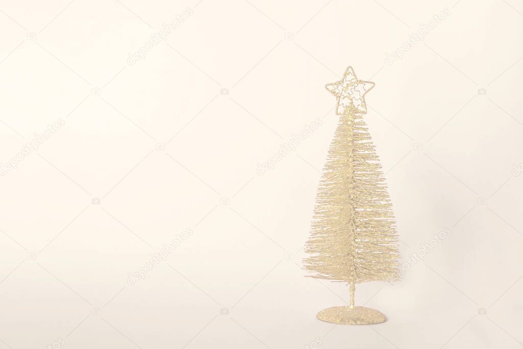 Christmas composition. Golden christmas tree decoration with glitters on Set Sail Champagne (color of year 2021) background. Mock up for new year gretting card. Copy space for text or lettering