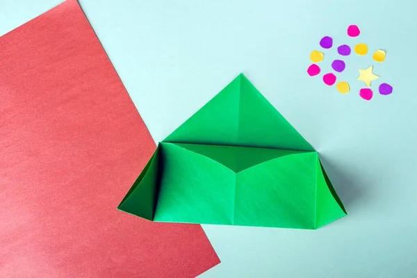 Concept of DIY and kid\'s creativity, origami. Step by step instruction: how to make bookmark as christmas tree. Step 4 Bend corners of triangle to middle. New year craft