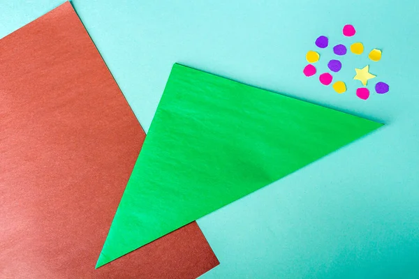 Concept of DIY and kid\'s creativity, origami. Step by step instruction: how to make bookmark as christmas tree. Step 2 fold square along diagonal. New year craft