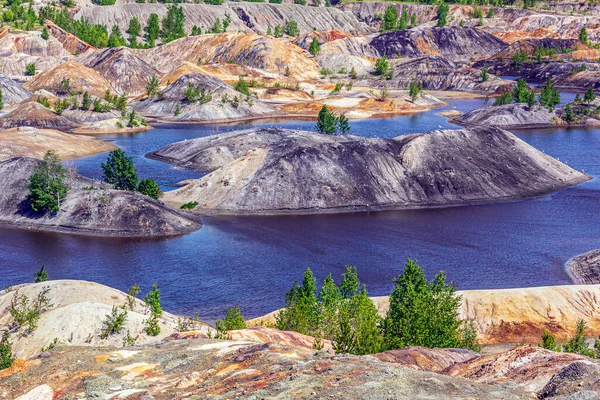 Apocalyptic landscape like a planet Mars surface. Fantastic view of blue lake. Solidified red-brown black Earth surface. Barren, cracked and scorched land. Global warming concept