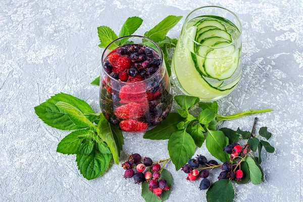 Variety of Fresh cool detox drink with berries and cucumber. Glasses of lemonade or flavored infuse water, tea. Proper nutrition and healthy eating. Fitness diet. Close up