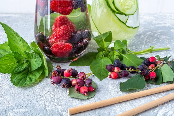 Variety of Fresh cool detox drink with berries and cucumber. Glasses of lemonade or flavored infuse water, tea. Proper nutrition and healthy eating. Fitness diet. Close up