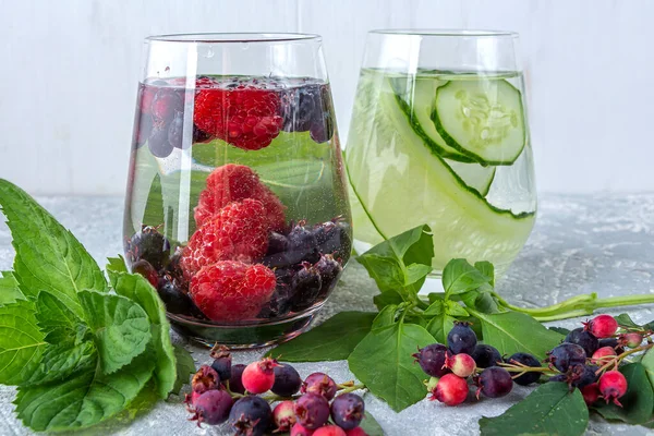 Variety of Fresh cool detox drink with berries and cucumber. Glasses of lemonade or flavored infuse water, tea. Proper nutrition and healthy eating. Fitness diet. Close up