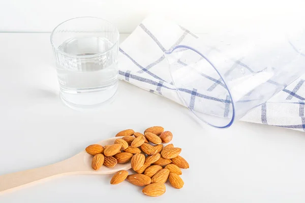 Step by step recipe. Cooking nuts vegetable milk. Step 1 ingredients: almonds, glass of water and blender. Homemade food concept. Plant based organic veggie milk, lactose free.