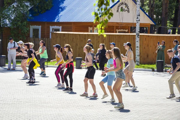 Yekaterinburg ロシア 2021 都市公園でズンバダンスを行う女性のグループ フィットネス 夏の天気の良い日に屋外でスポーツ活動をしている明るいスポーツウェアの人々 — ストック写真