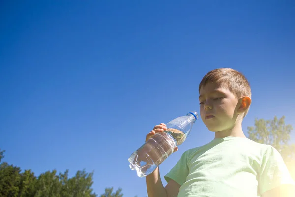 Mały Chłopiec Lat Pije Czystą Wodę Plastikowej Butelki Przeciwko Błękitnemu — Zdjęcie stockowe