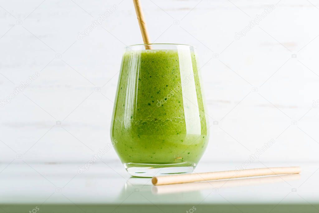 Green smoothie from spinach, apple, cucumber and soy milk in glass on white background. Home cooking. Vegan healthy detox eating, dietary and weight loss drink. 