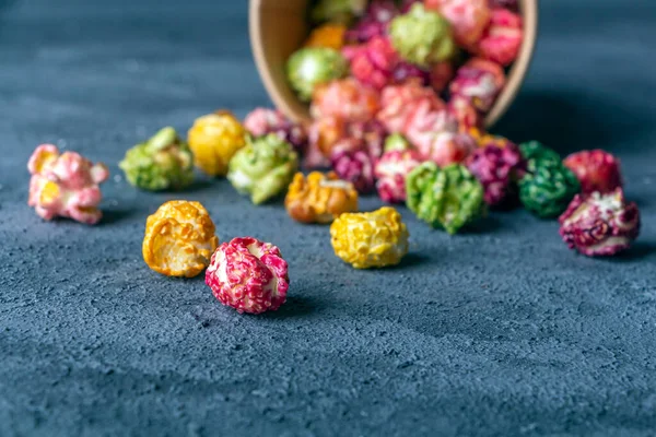 Colorful rainbow caramel candy popcorn on dark background. Cinema snack concept. Food for watching movie and entertainment. Copy space for text, close up