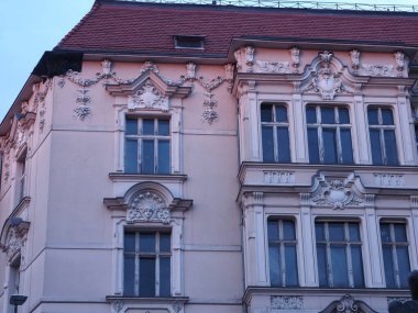 Szczecin Polonya 'da dekoratif sıva ayrıntıları ve kırmızı kiremitli çatı (Papa 2. John Paul Caddesi, Szczecin) - Polonya' nın Szczecin kentindeki tarihi konut cephesi, sıva süslemeleri, kırmızı kiremitli çatı.