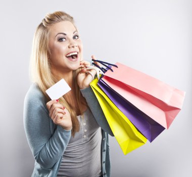 Güzel sarışın giysileri üzerinde çalışır. Parlak elbiseler. Alışveriş. Dolaba koyun.