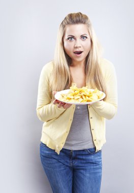 Patates cipsi ile genç kız. O düşünüyor. Sarışın izle diyet