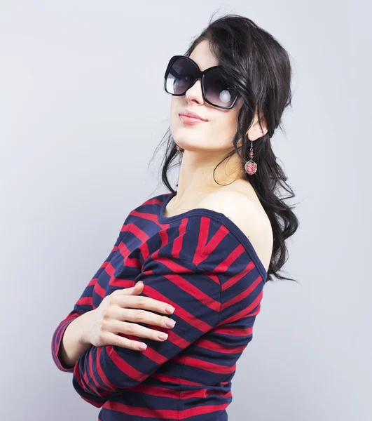 Beautiful brunette in sunglasses. Young girl in a striped dress — Stock Photo, Image