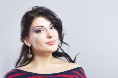 Çizgili bir elbise güzel kız. Siyah bir zemin üzerine esmer gülümseyen. Akıllı kadın portresi