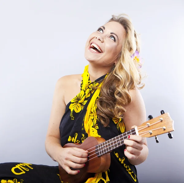 Vrolijke jonge blonde in een Hawaiiaanse sjaal. Meisje speelt op ukulele. Hawaii stijl. Portret van een lachende vrouw — Stockfoto