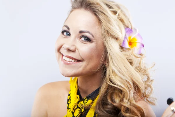 Joven rubia alegre en una bufanda hawaiana. La chica juega con el ukelele. Al estilo Hawaii. Retrato de una mujer sonriente —  Fotos de Stock