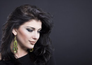 Güzel esmer ile uçan bir saç. Takı güzel bir kızın portresi. Parlak saçlar. Moda. Güzel kadın süsler