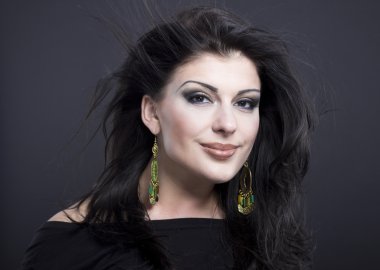 Güzel esmer ile uçan bir saç. Takı güzel bir kızın portresi. Parlak saçlar. Moda. Güzel kadın süsler